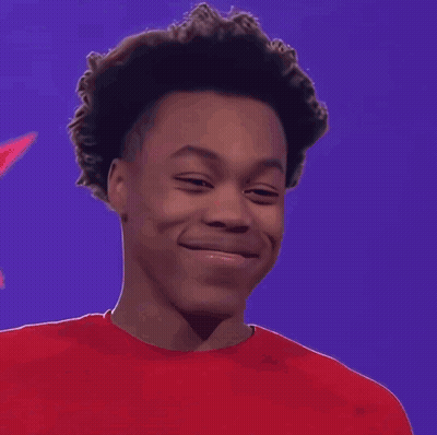 A Young Man Wearing A Red Shirt Is Smiling GIF