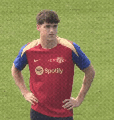 A Young Man Wearing A Red Spotify Shirt Is Standing On A Field . GIF