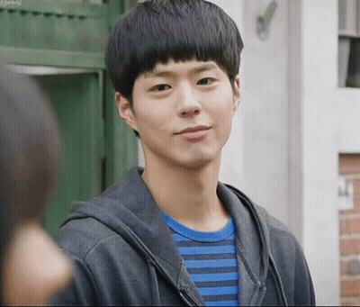 A Young Man Wearing A Striped Shirt And A Black Jacket Looks At The Camera GIF