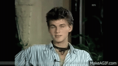 A Young Man Wearing A Striped Shirt And A Choker Is Sitting In A Chair With His Eyes Closed . GIF