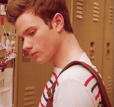 A Young Man Wearing A Striped Shirt And Carrying A Purse GIF
