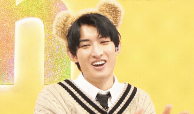 A Young Man Wearing A Sweater And Tie With Teddy Bear Ears On His Head Is Smiling . GIF