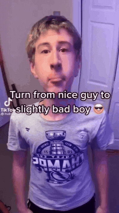 A Young Man Wearing A T-Shirt That Says `` Turn From Nice Guy To Slightly Bad Boy '' GIF