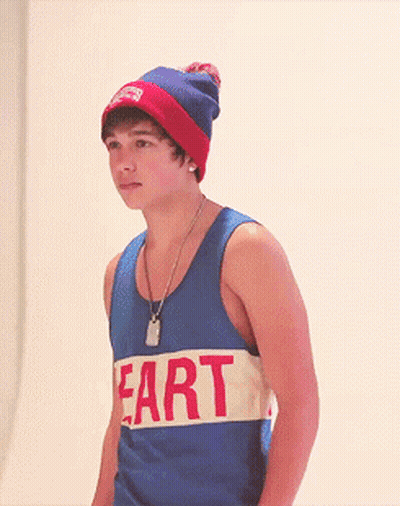 A Young Man Wearing A Tank Top That Says Fart On It GIF