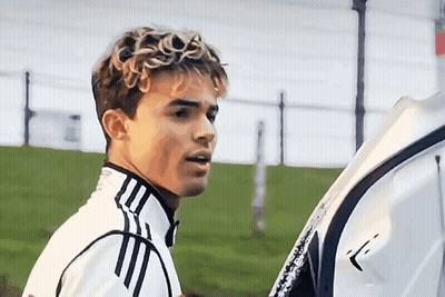 A Young Man Wearing A White Adidas Jacket Stands In A Field GIF