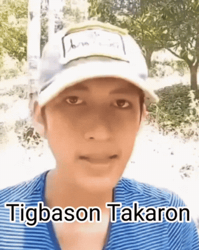 A Young Man Wearing A White Hat And A Blue Shirt Is Talking . GIF