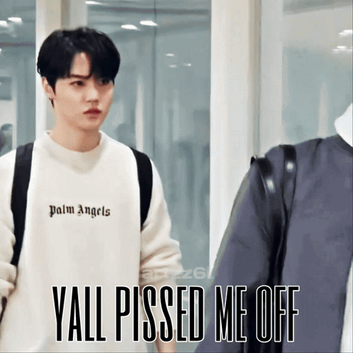 A Young Man Wearing A White Palm Angels Sweatshirt Stands Next To Another Man GIF