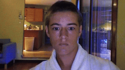 A Young Man Wearing A White Robe Is Making A Funny Face GIF