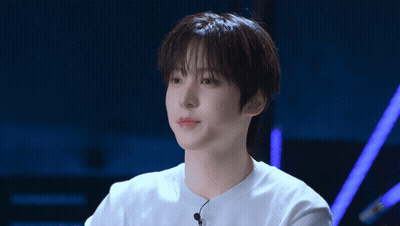 A Young Man Wearing A White Shirt With A Microphone Attached To It GIF
