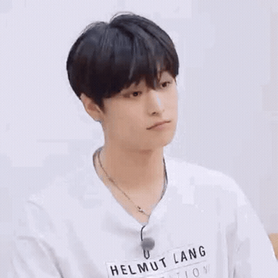 A Young Man Wearing A White T-Shirt And A Necklace . GIF