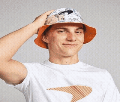 A Young Man Wearing A White T-Shirt And An Orange Bucket Hat . GIF