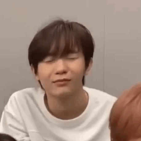 A Young Man Wearing A White T-Shirt Is Making A Funny Face . GIF