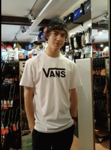 A Young Man Wearing A White Vans Shirt GIF