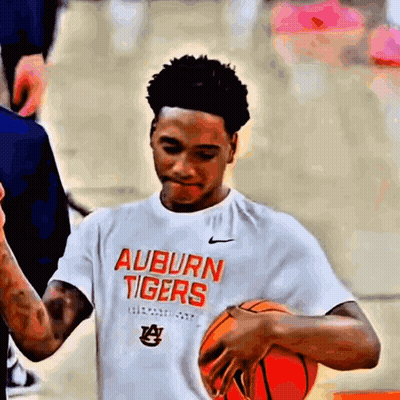 A Young Man Wearing An Auburn Tigers T-Shirt Holds A Basketball GIF
