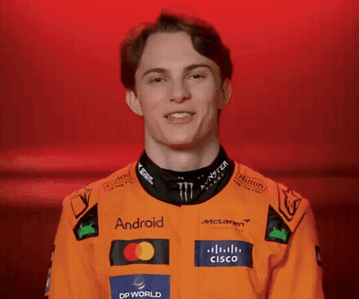 A Young Man Wearing An Orange Jacket With Logos For Android And Cisco On It GIF
