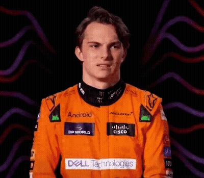 A Young Man Wearing An Orange Racing Suit With Dell Technologies Written On It GIF