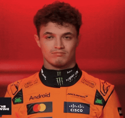 A Young Man Wearing An Orange Racing Suit With Logos For Android And Cisco GIF