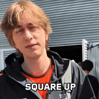 A Young Man Wearing An Orange Shirt And A Black Jacket With The Words Square Up Above Him GIF