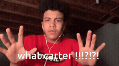 A Young Man Wearing Ear Buds And A Red Shirt Says What Carter GIF