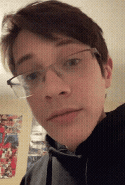 A Young Man Wearing Glasses And A Black Hoodie GIF