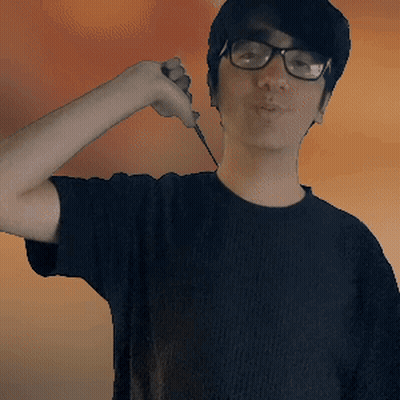 A Young Man Wearing Glasses And A Black Shirt Is Holding A Knife GIF