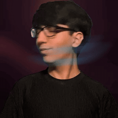 A Young Man Wearing Glasses And A Black Shirt Looks At The Camera GIF