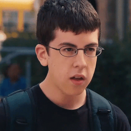 A Young Man Wearing Glasses And A Black Shirt Looks Surprised GIF