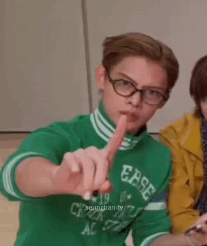 A Young Man Wearing Glasses And A Green Shirt With Ease Written On It GIF