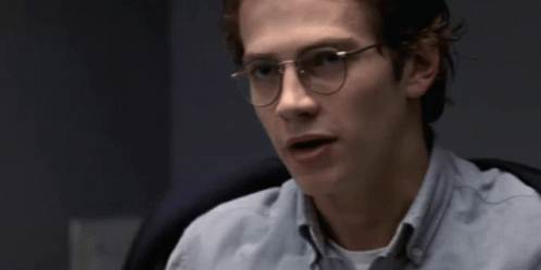 A Young Man Wearing Glasses And A Light Blue Shirt GIF