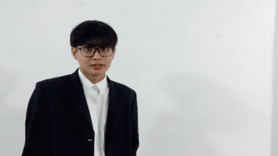 A Young Man Wearing Glasses And A Suit Is Making A Funny Face GIF