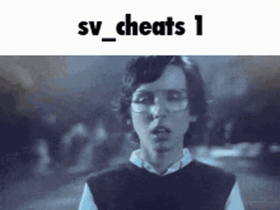 A Young Man Wearing Glasses And A Vest Is Standing In Front Of A Sign That Says Sv_cheats 1 GIF