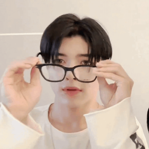 A Young Man Wearing Glasses And A White Shirt Is Making A Funny Face . GIF