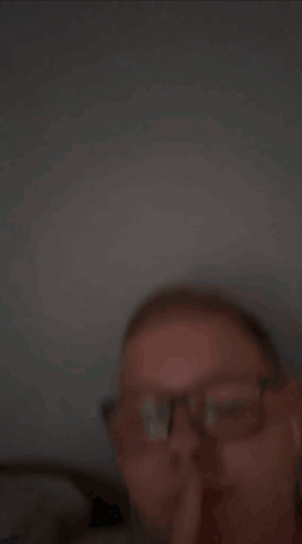A Young Man Wearing Glasses And Earbuds Is Making A Funny Face GIF