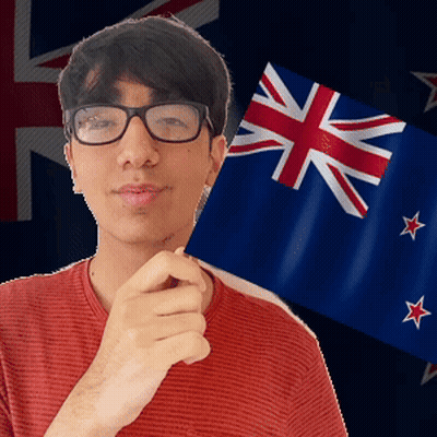 A Young Man Wearing Glasses Holds A Small Flag In Front Of A British Flag GIF