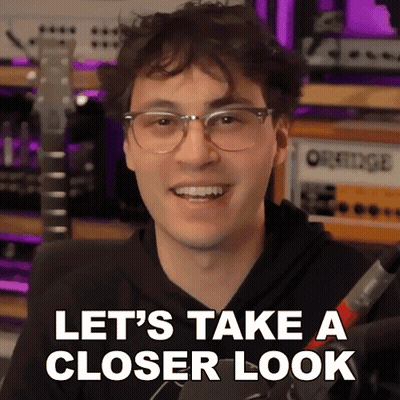 A Young Man Wearing Glasses Is Smiling And Says Let 'S Take A Closer Look GIF