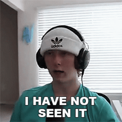A Young Man Wearing Headphones And A Beanie Is Making A Funny Face . GIF