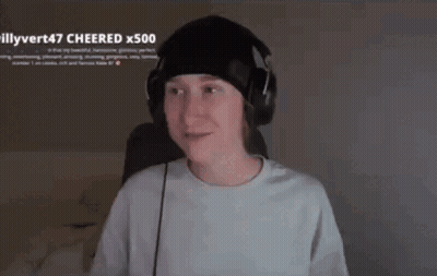 A Young Man Wearing Headphones And A Beanie Is Sitting In Front Of A Computer Screen . GIF