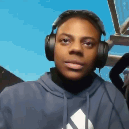A Young Man Wearing Headphones And A Blue Hoodie . GIF