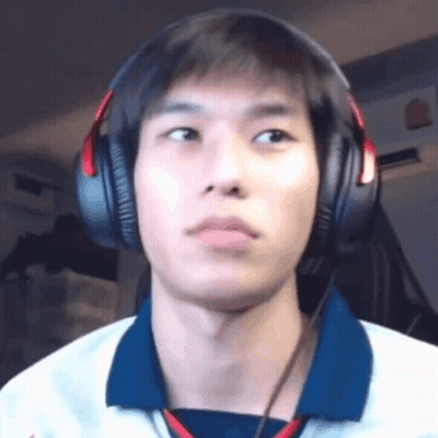 A Young Man Wearing Headphones And A Blue Shirt Is Looking At The Camera . GIF