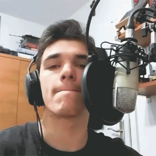 A Young Man Wearing Headphones And A Microphone GIF
