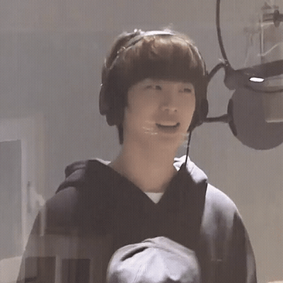 A Young Man Wearing Headphones And A Microphone Is Laughing . GIF