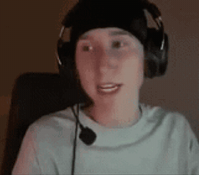 A Young Man Wearing Headphones And A Microphone Is Sitting In A Chair . GIF