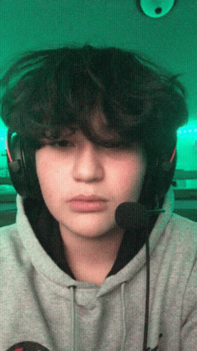 A Young Man Wearing Headphones And A Microphone Looks At The Camera GIF