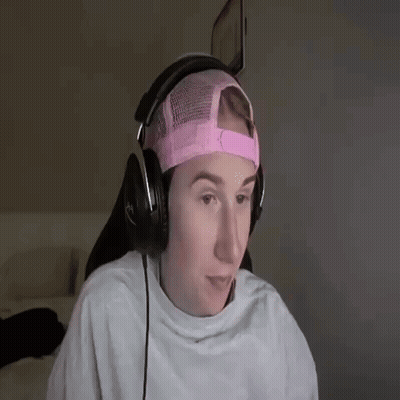 A Young Man Wearing Headphones And A Pink Hat . GIF