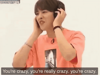 A Young Man Wearing Headphones And A Pink Shirt Is Talking To Someone . GIF