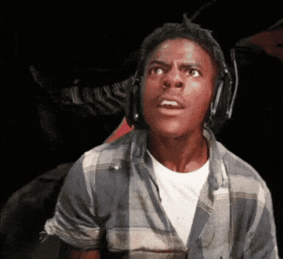 A Young Man Wearing Headphones And A Plaid Shirt Is Making A Surprised Face . GIF