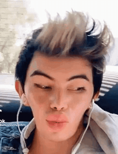 A Young Man Wearing Headphones And Making A Funny Face . GIF