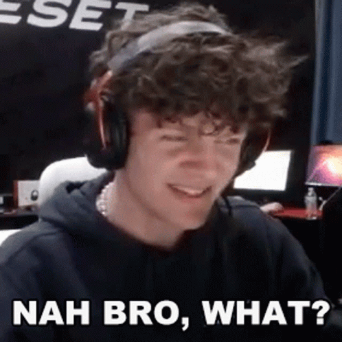 A Young Man Wearing Headphones Is Making A Funny Face While Sitting In Front Of A Computer . GIF