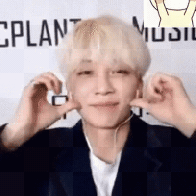 A Young Man Wearing Headphones Is Making A Heart Shape With His Hands . GIF