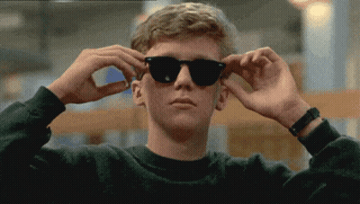 A Young Man Wearing Sunglasses Adjusts His Glasses GIF